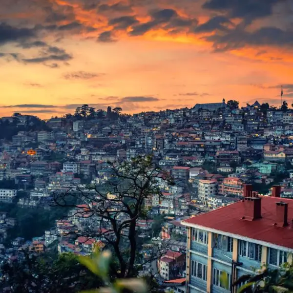 Beautiful sunset over a mountain slope engulfed with buildings in Shimla, North India