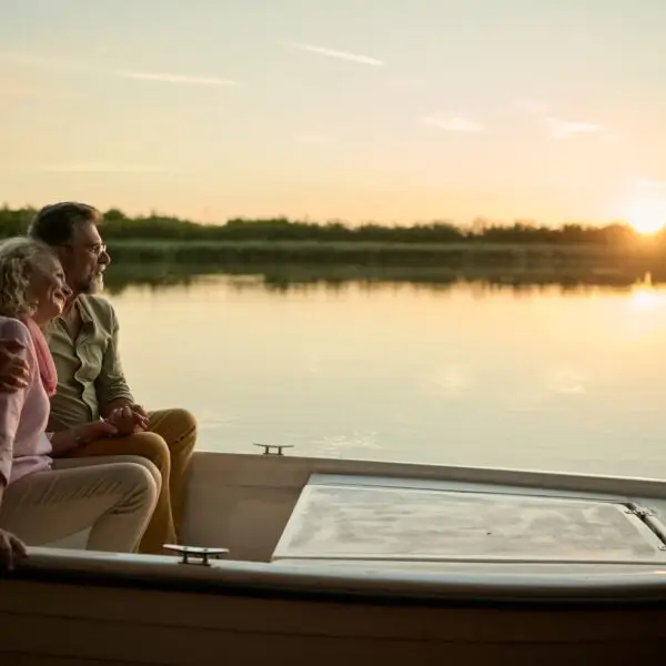 Romantic senior couple enjoying sunset boat ride on lake