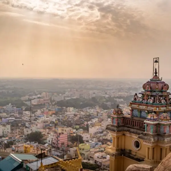 Roof of the ancient temple in Trichy India with the cityscape in the sunny background