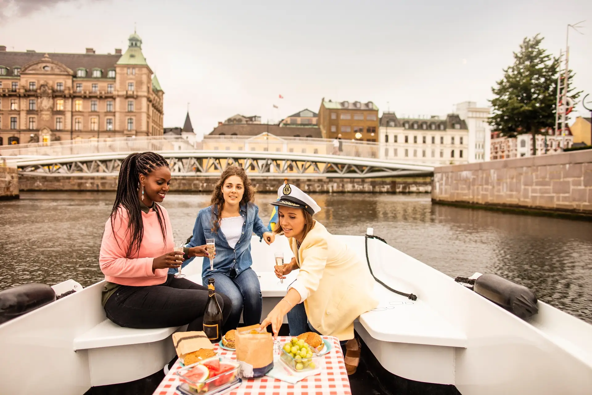Young female friends having picnic on boat tour